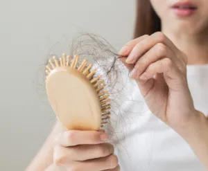 ブラシの髪の毛を取る女性